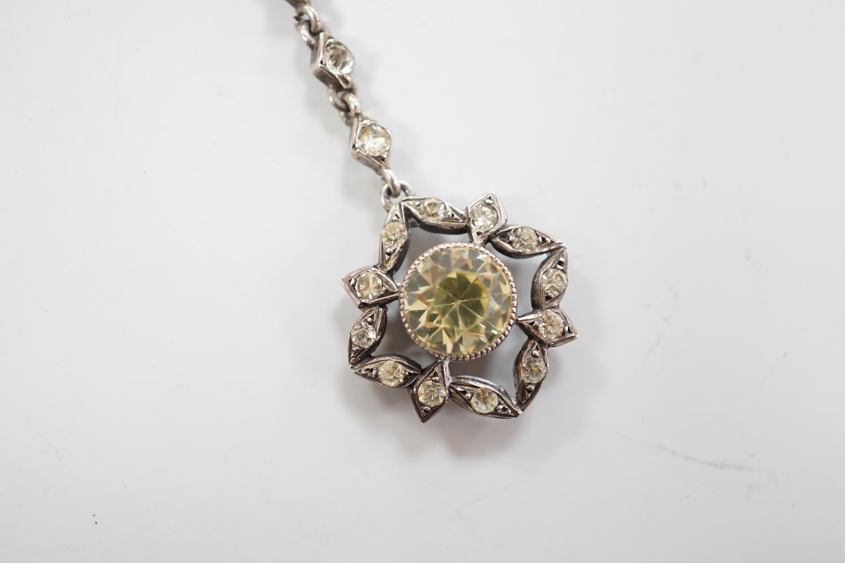 A 19th century white metal and foil backed paste set pendant, 40mm, on a later two colour chain, the clasp stamped 9ct.